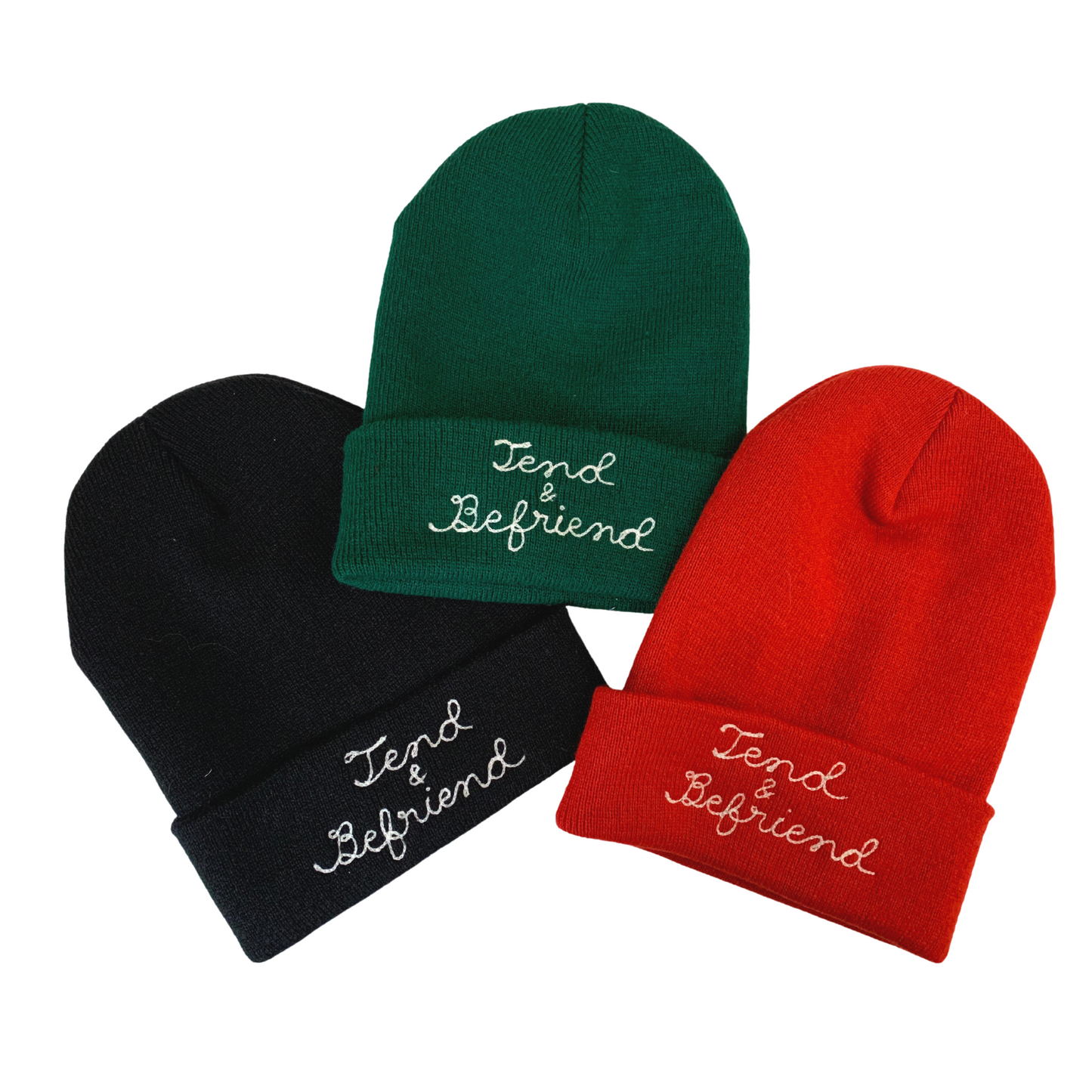 Group of black, green, and red knit beanies with cursive lettering embroidered with chainstitch embroidery.